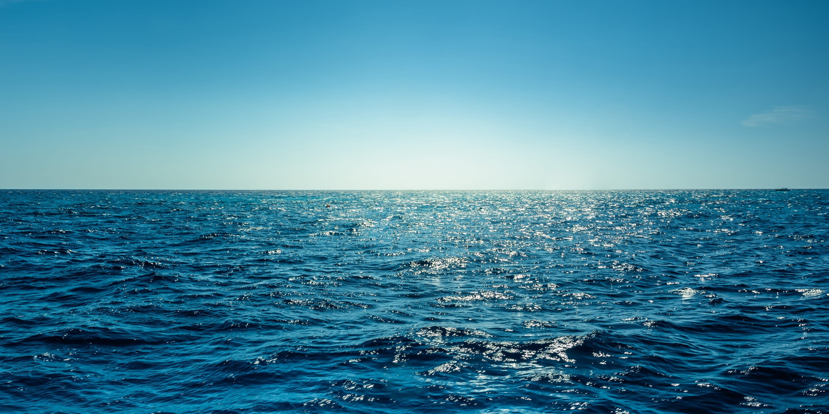 Mar abierto con el horizonte despejado y destellos de sol sobre el agua