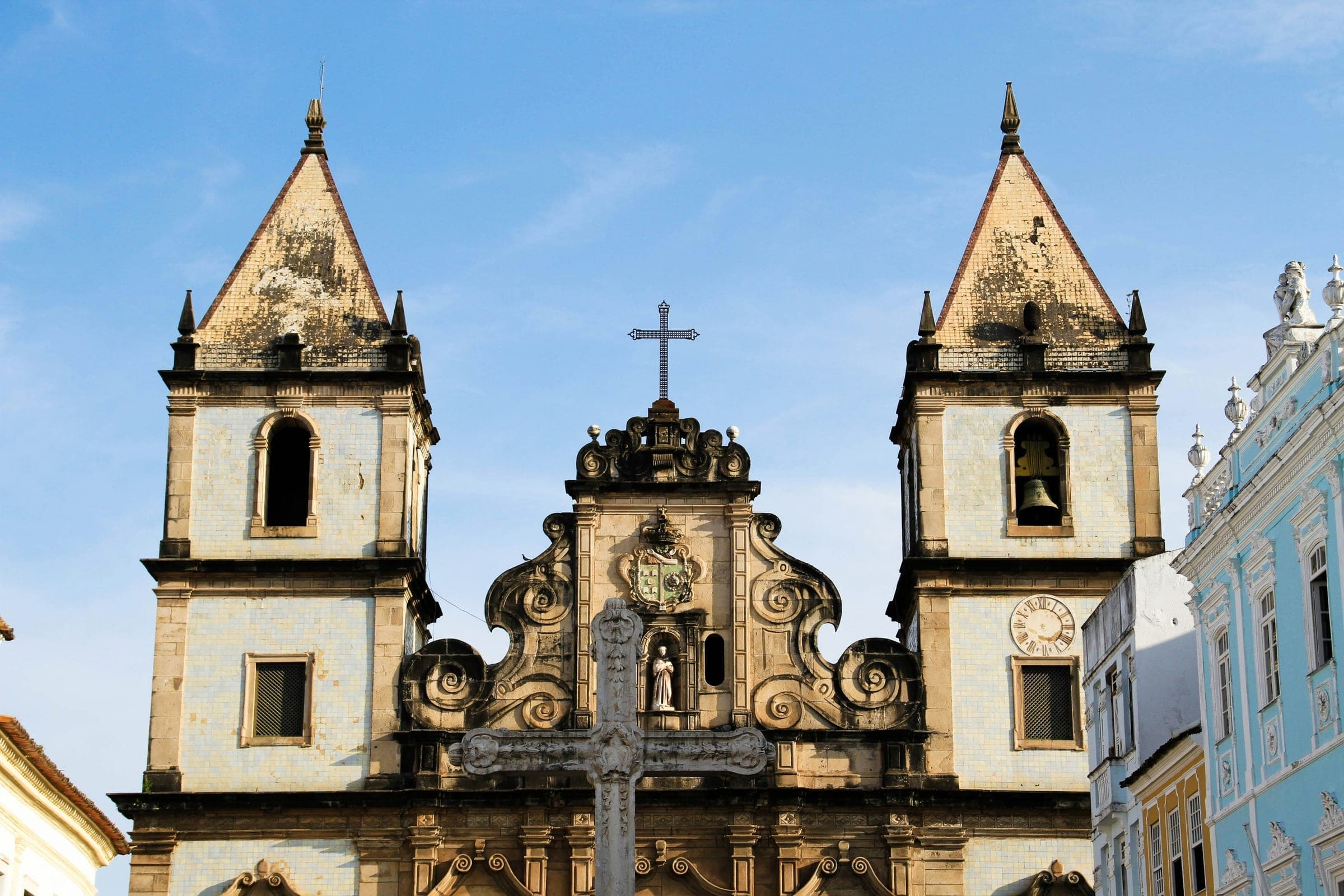 La fachada barroca de la iglesia de São Francisco, con sus dos torres y la cruz de piedra delante, en el Pelourinho